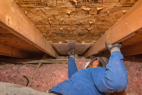 NorthStar employee installing air chute in attice